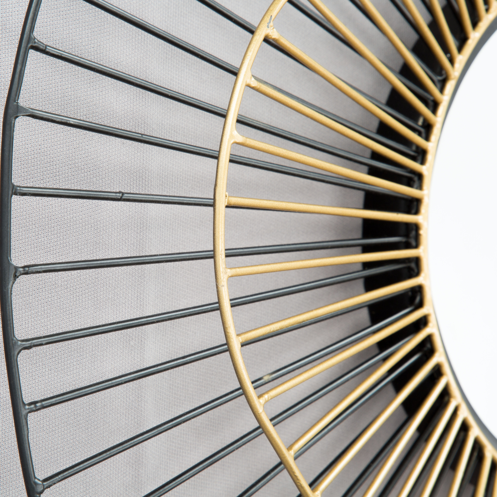 Detalle del acabado dorado y negro en la estructura del espejo